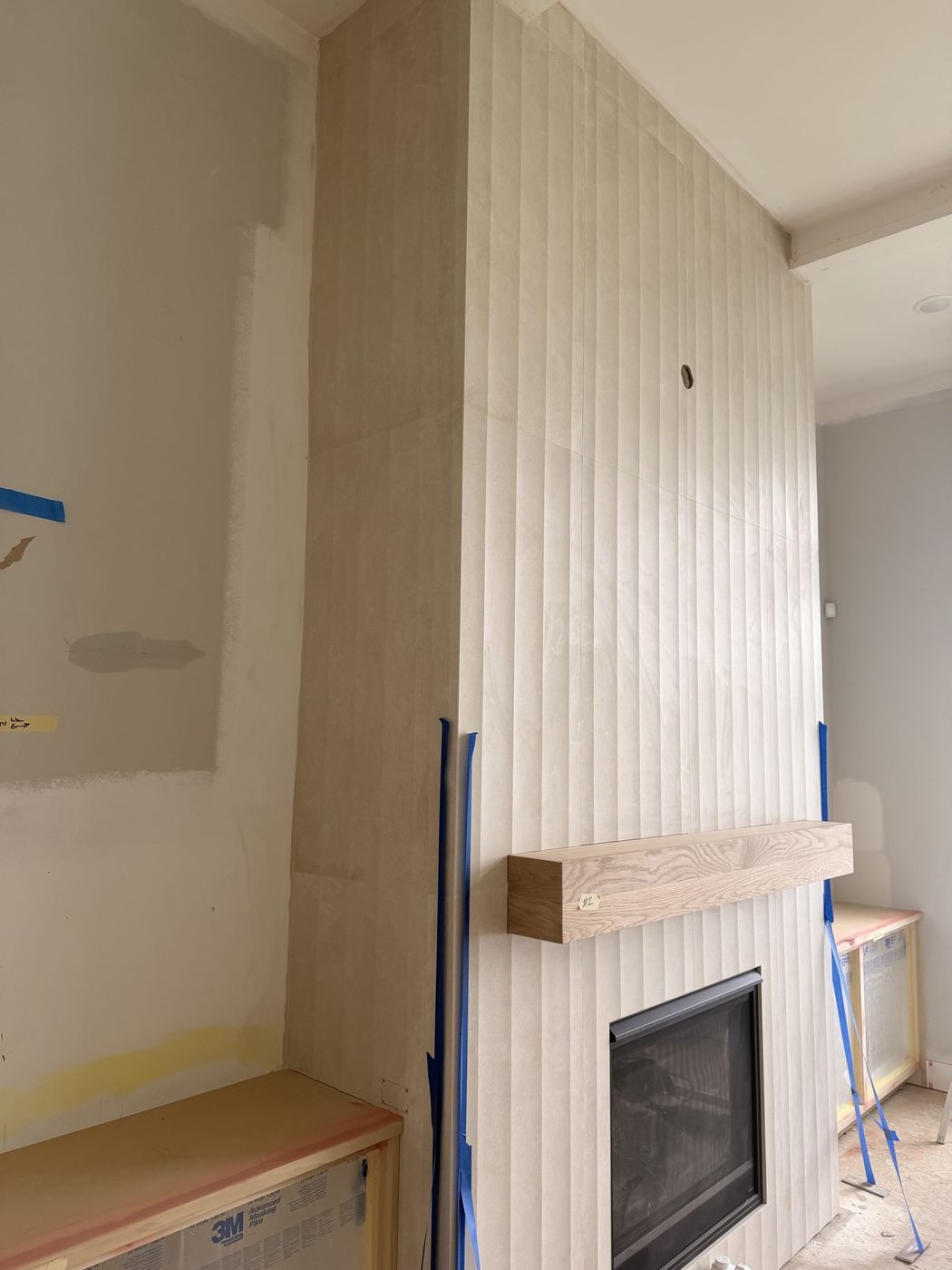Fireplace wall in fluted tile with a wood mantel