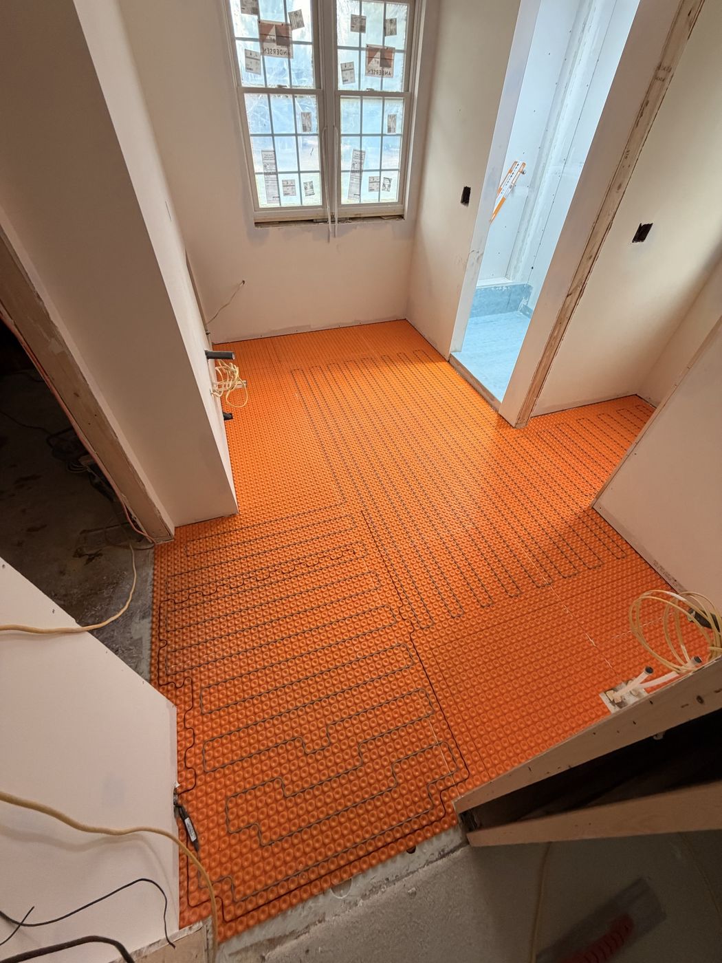Heated floor cable system being installed before tile