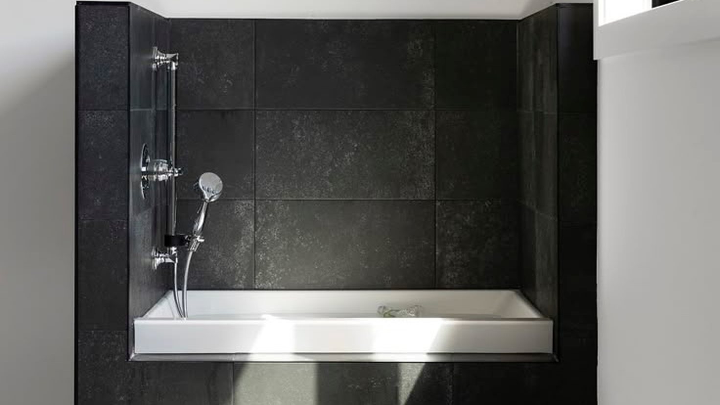 Tub surround in large dark stone-look tile