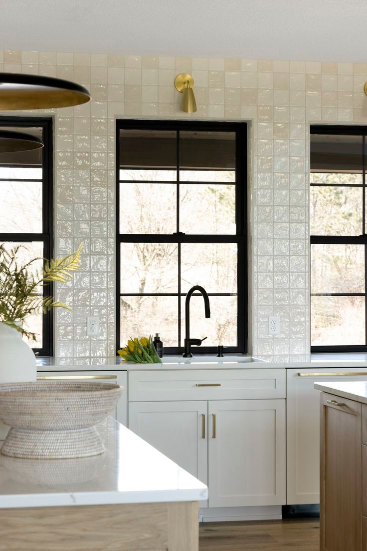 Kitchen with a glossy handmade-look tile backsplash around black windows