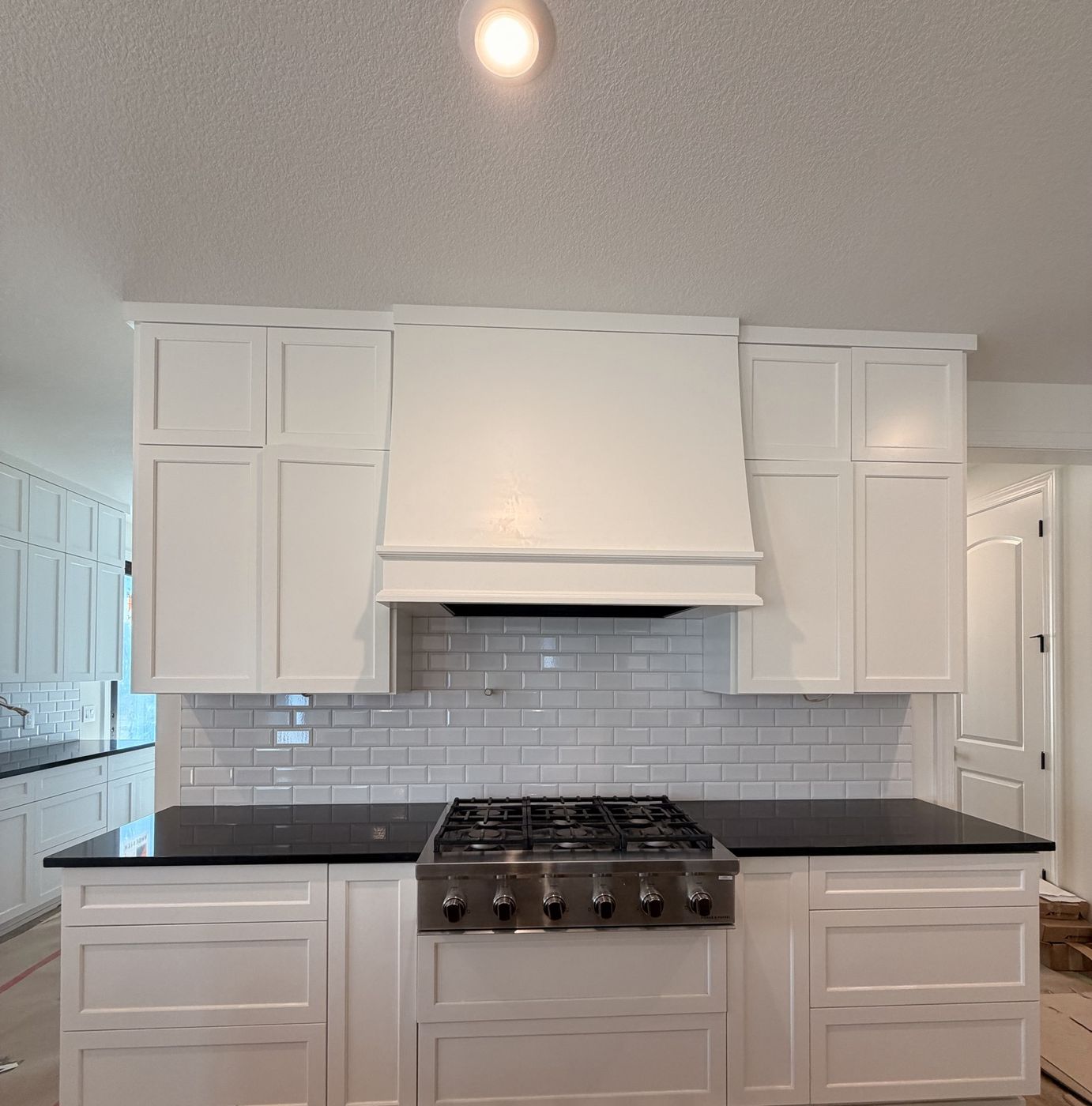 White kitchen with a subway tile backsplash behind the range