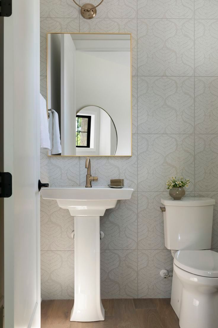 Powder room with a patterned white tile feature wall