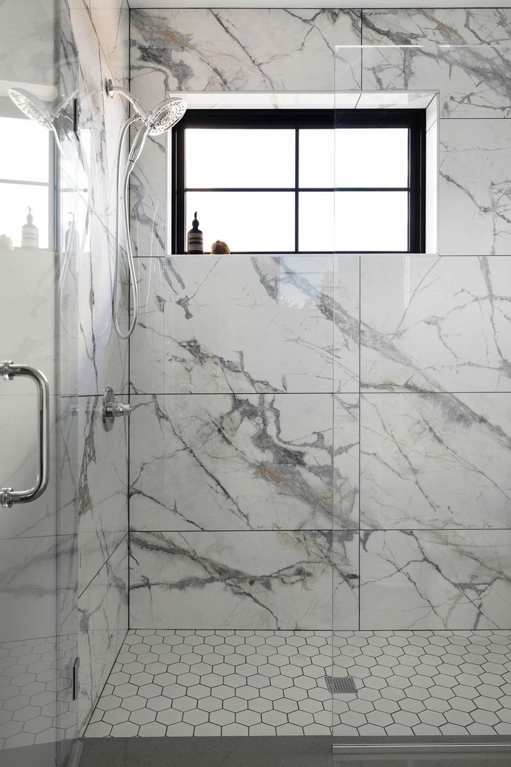 Shower with oversized marble-look tile and a hexagon mosaic floor