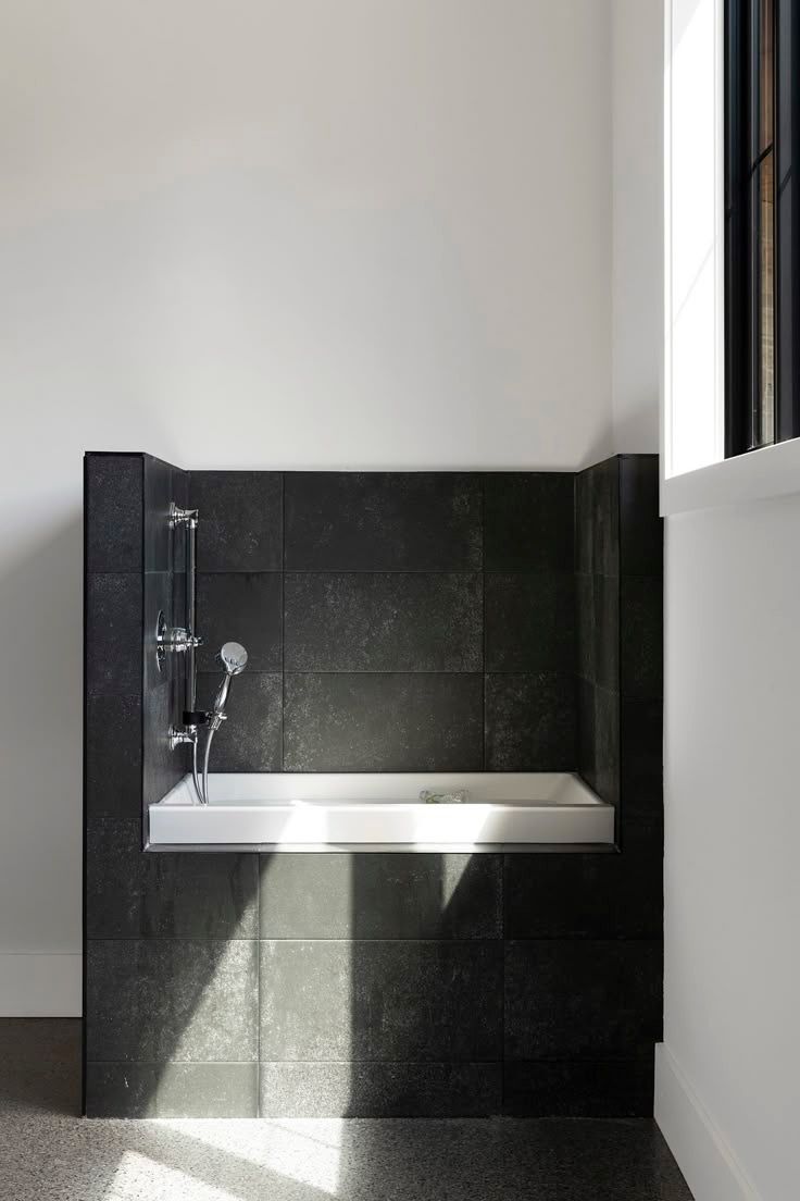 Bathtub surround in large dark stone-look tile